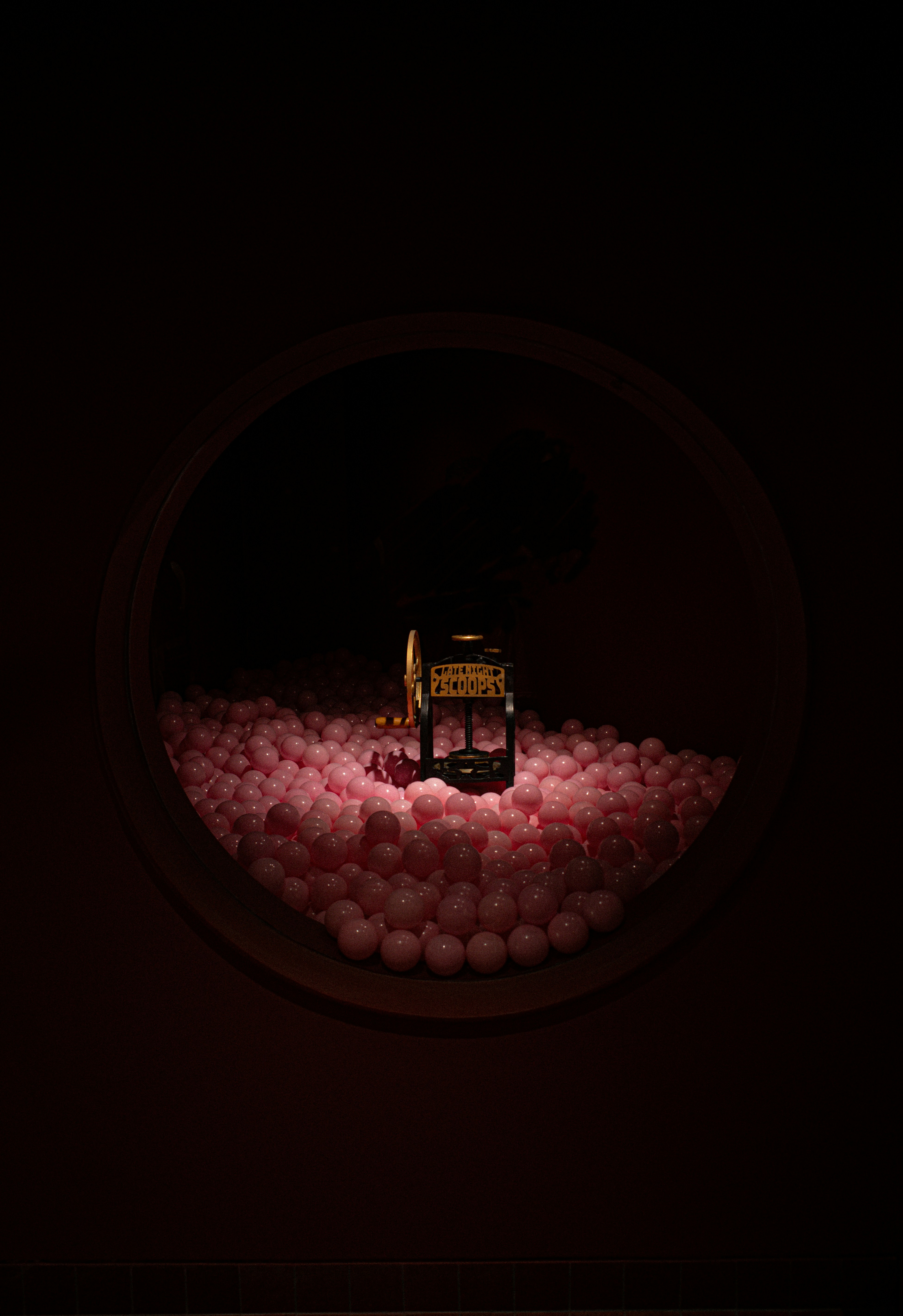 A picture of a chair in the middle of a room filled with balls